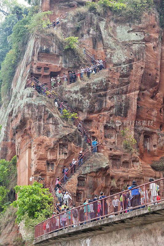 人们走过世界s最高的佛像在乐山，中国